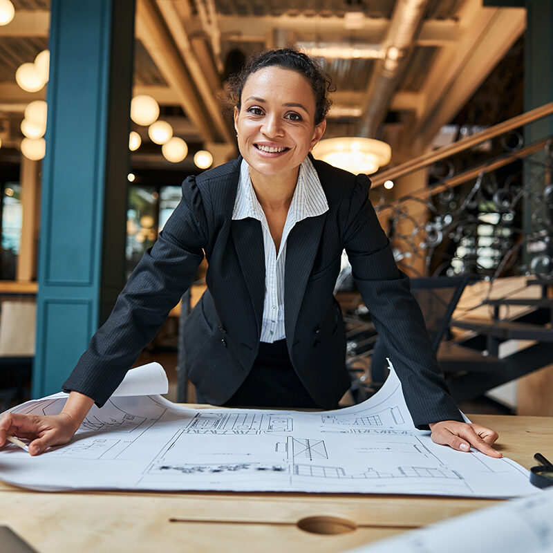 Positive delighted international female leaning on table